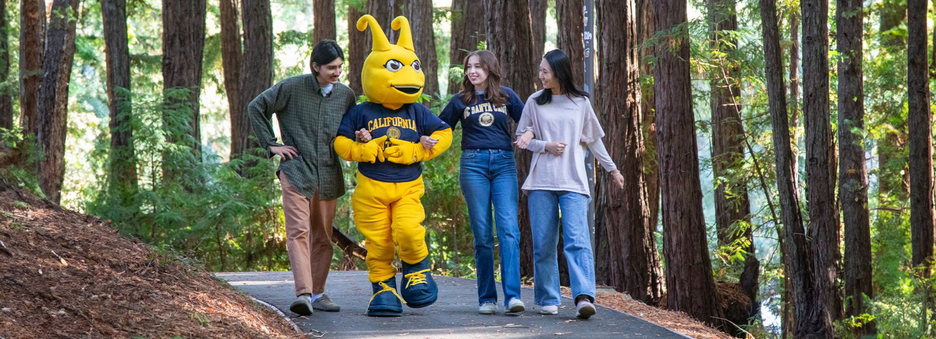 Students walk with Sammy the Slug in the redwoods